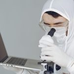 person-in-personal-protective-equipment-holding-a-laptop-4149045